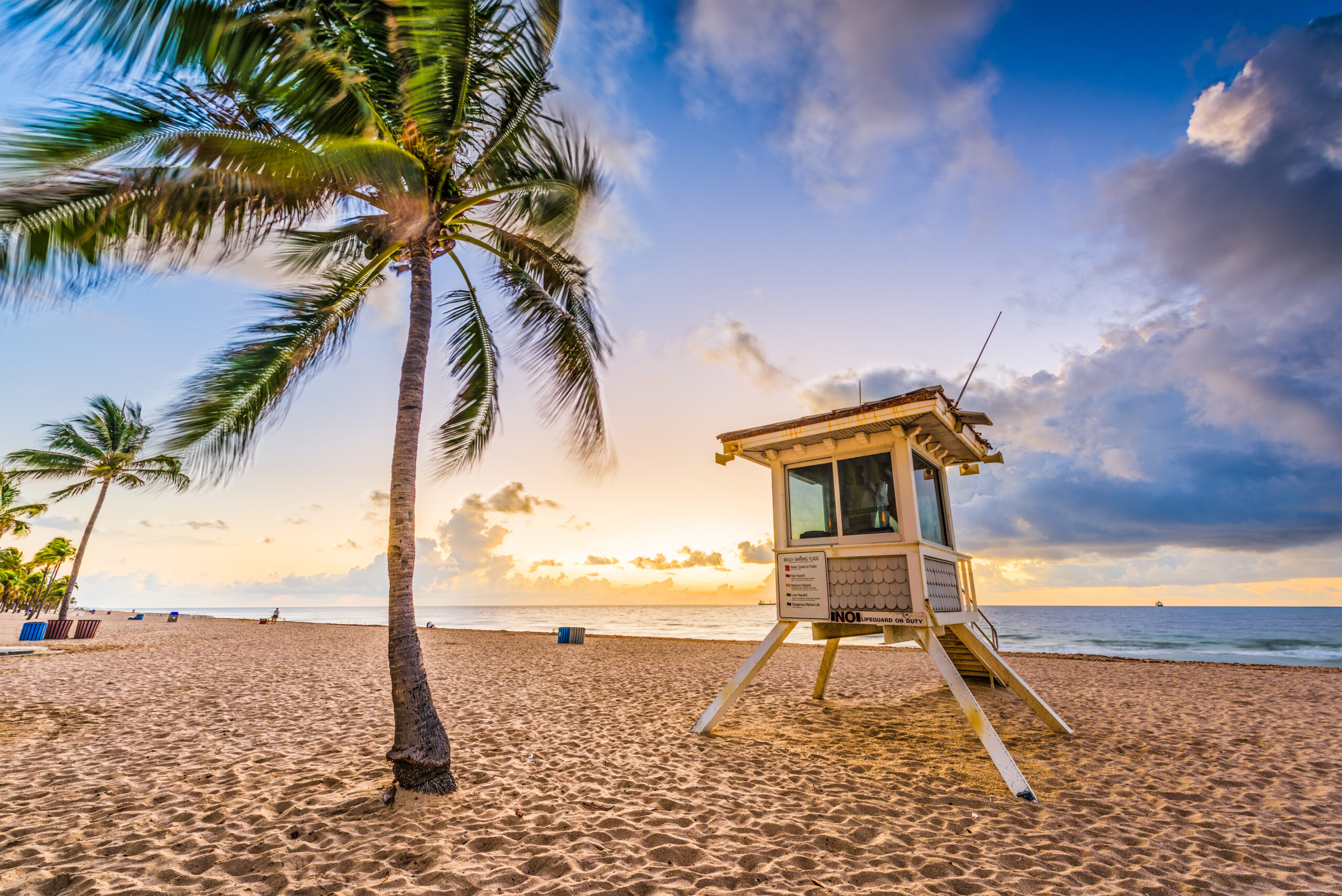 Sunset view of Boynton Beach with lifeguard tower and palm trees