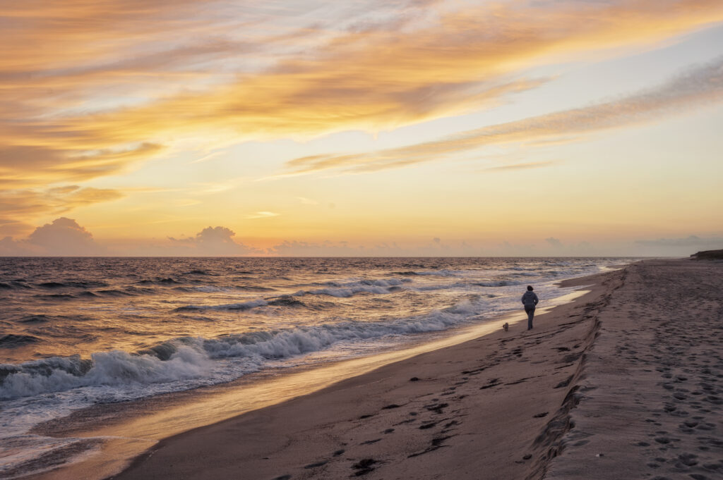 Sunset at Boynton Beach with silhouetted figure walking along the shore