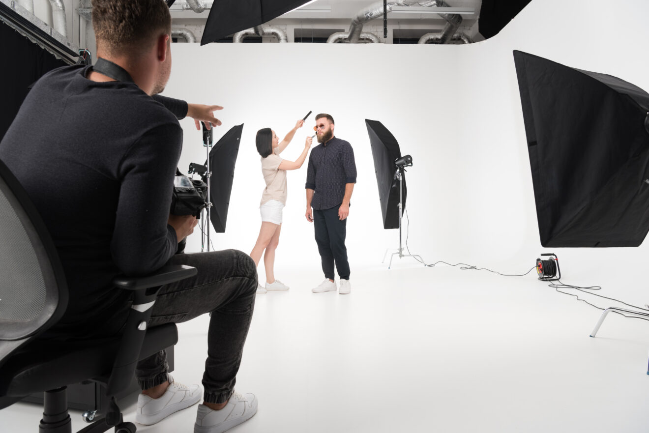 Stylist working on a man's hair in photography studio