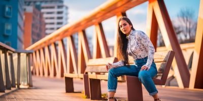 Girl in high heels and jeans on bridge at sunset photoshoot, fashion tips