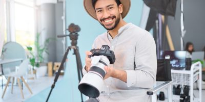 Smiling photographer holding camera, ready to capture precious family memories. Childrens photography.