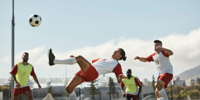 Female athlete mid-kick in a dynamic soccer game, showcasing action photography techniques.